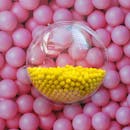 Bright yellow balls in a clear sphere against a backdrop of pink balls in Calgary.